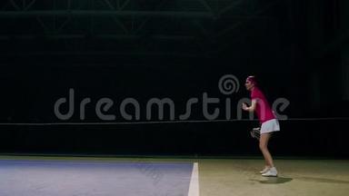 一个穿着粉红色T恤和白色裙子的女人在网球比赛中<strong>打球</strong>。 网球运动员学会<strong>打球</strong>